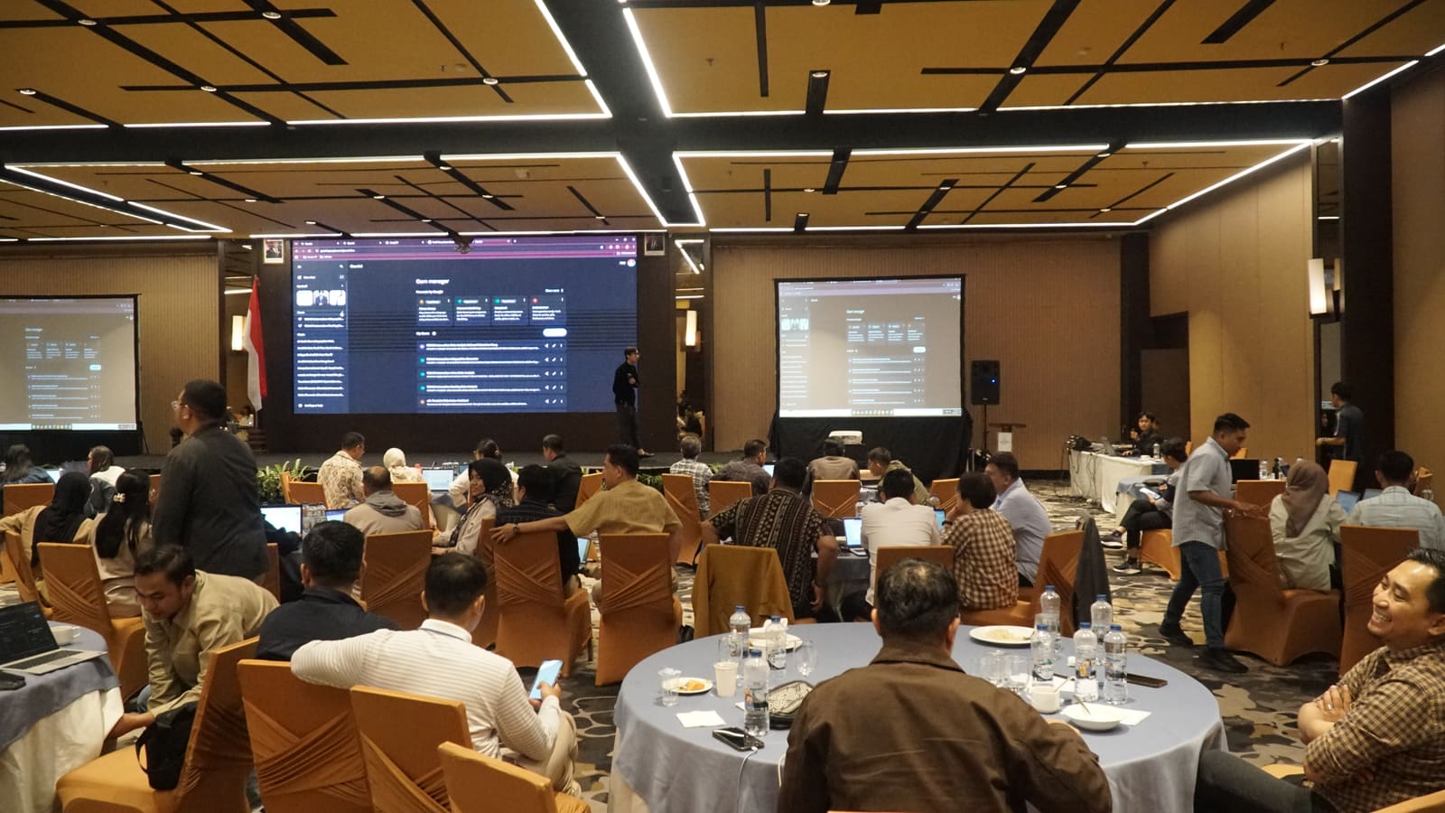Fahmi Fahreza's session at Bank Indonesia, the training room with participants at round tables facing two projector screens