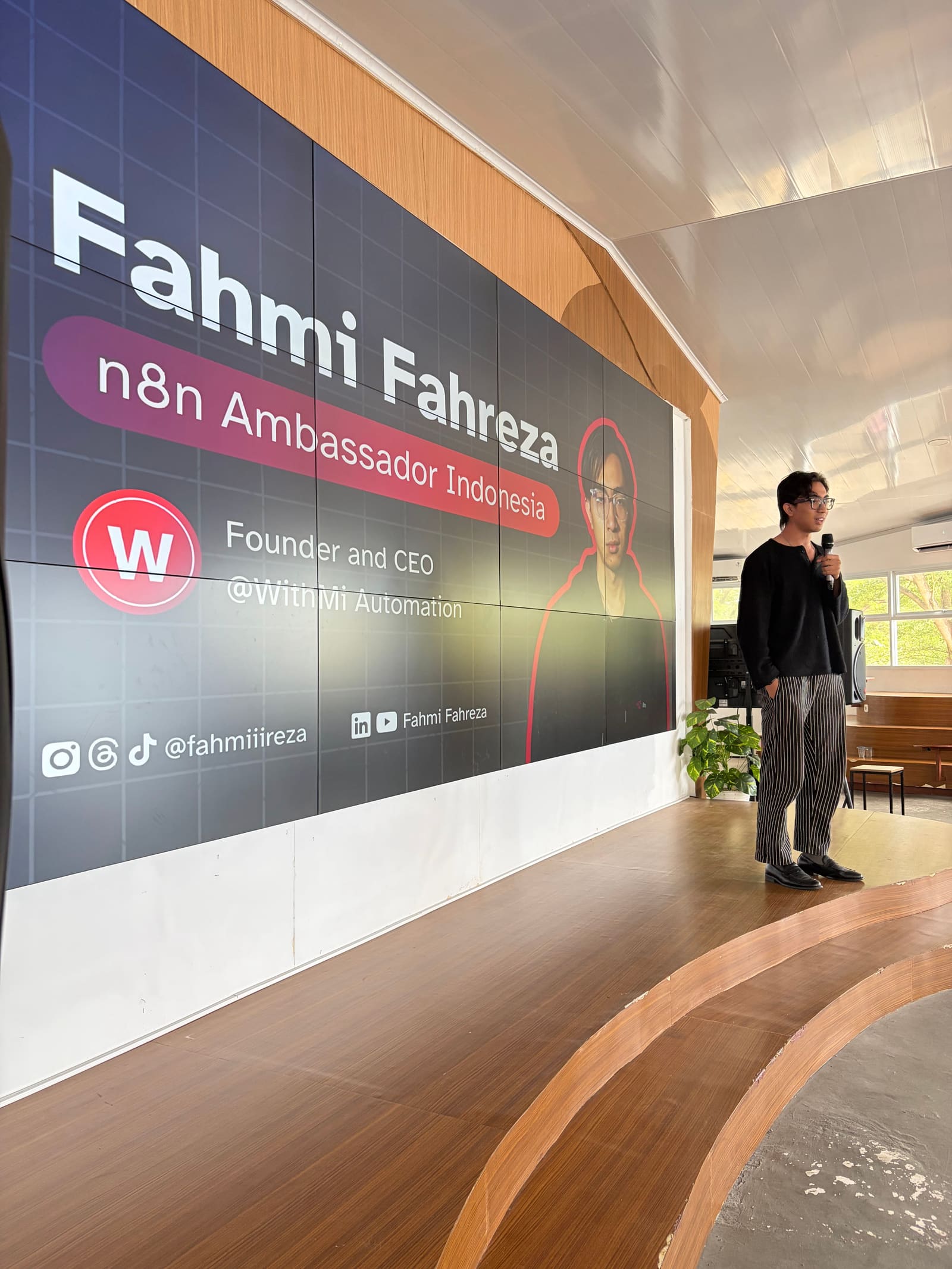 Fahmi Fahreza membuka sesi Batch 1 di Makassar Creative Hub, layar menampilkan kartu pembicara n8n Ambassador Indonesia dan WithMi Automation