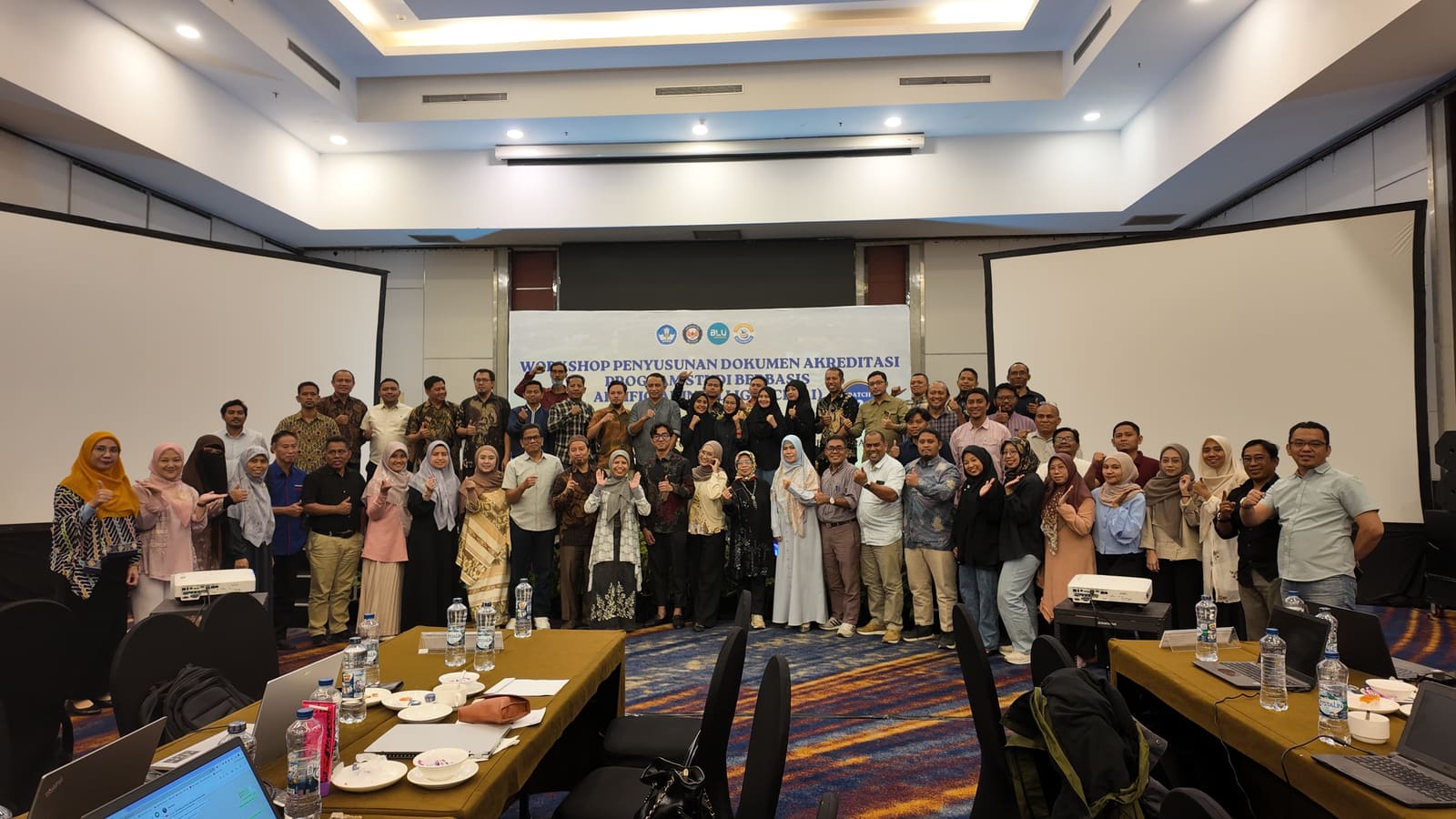 Group photo of the AI-based accreditation workshop participants at Universitas Halu Oleo, taken in the training room facing the event backdrop