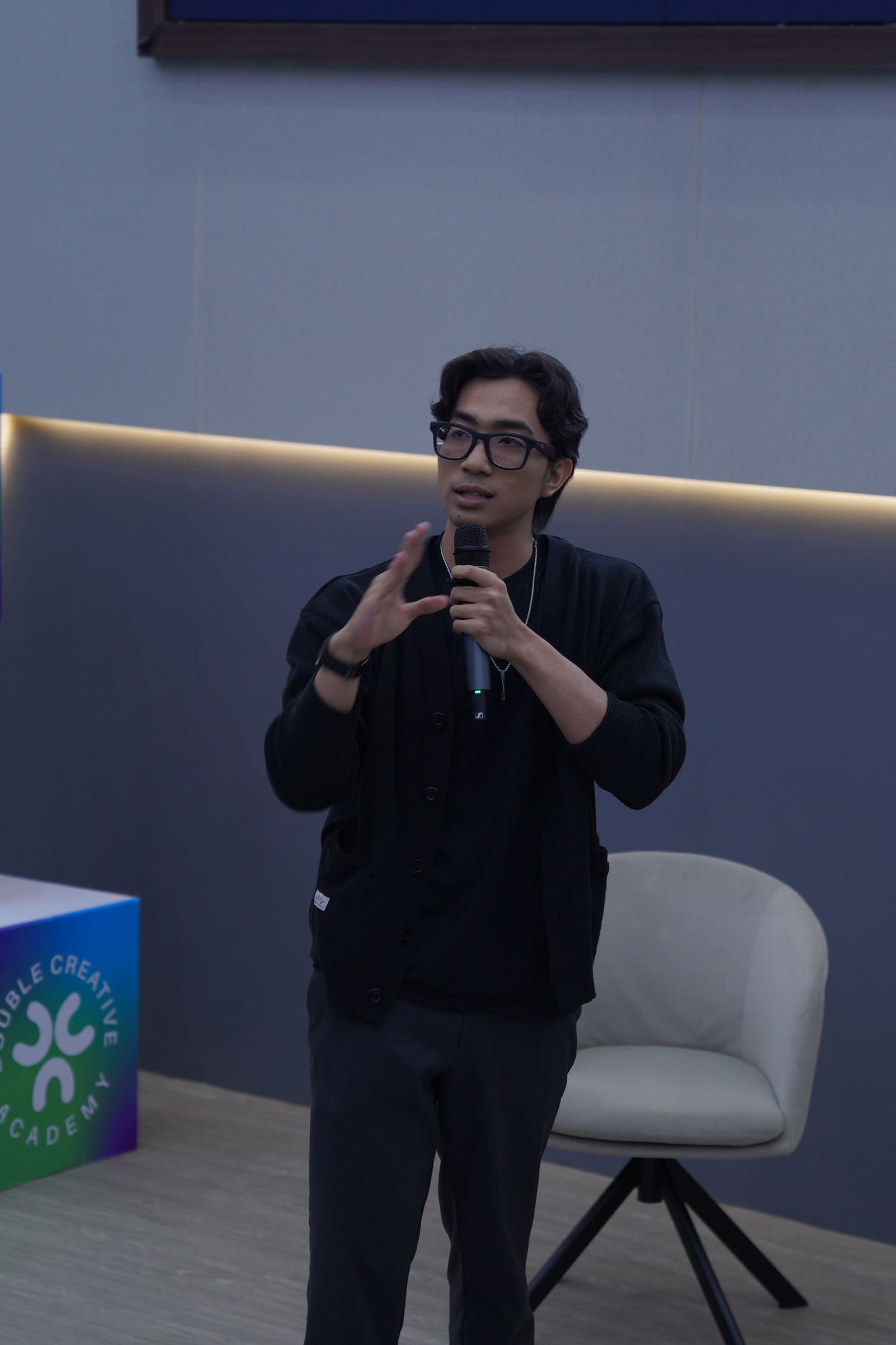 Fahmi Fahreza explaining the material with a handheld microphone at the Universitas Hasanuddin Campus Community session